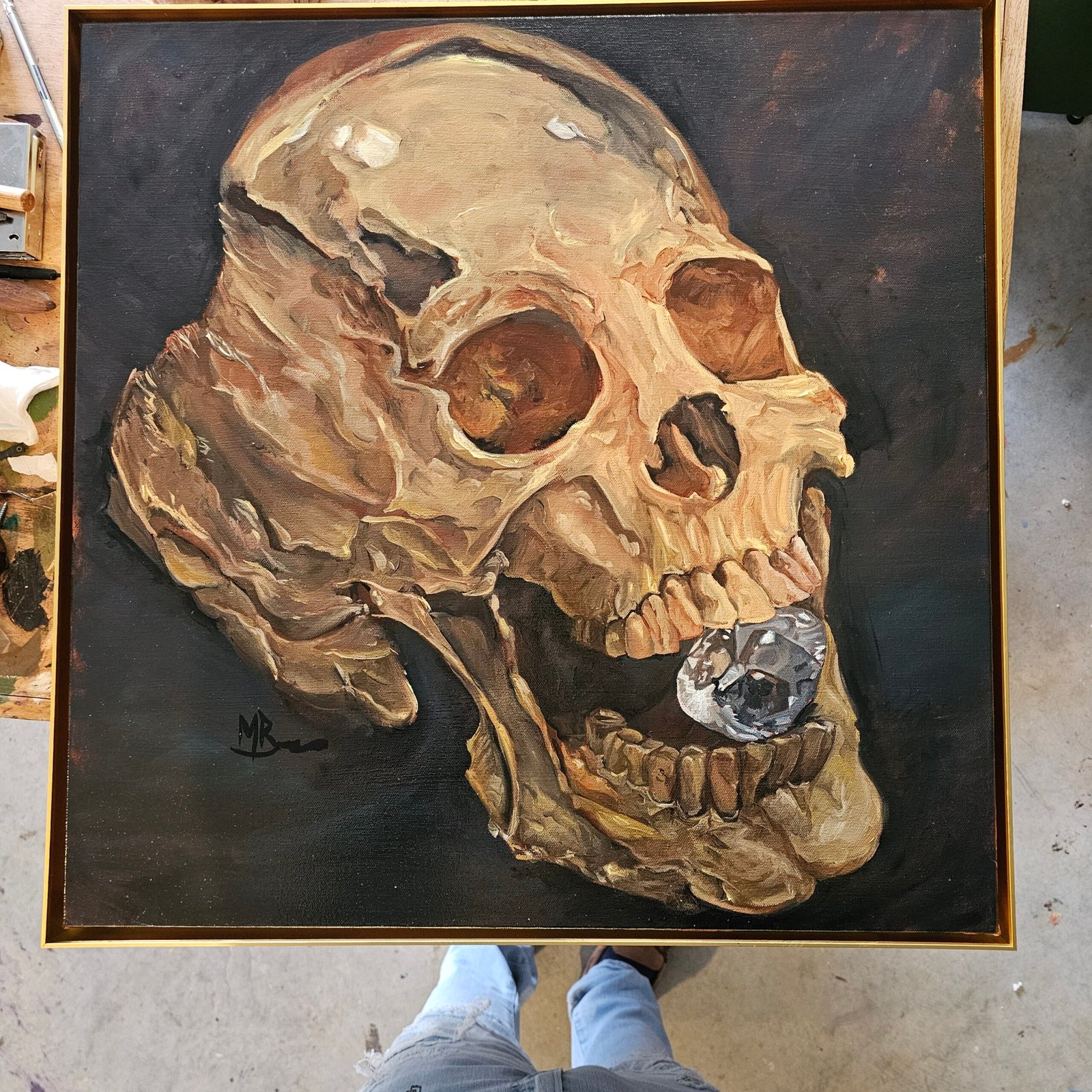 AMOR FATI
24x24 Oil on canvas
🖼️ Artwork Details
Artist: Matthew Bishop
Medium: Oil on Canvas
Theme: Memento Mori / Vanitas
Detailed Description
The piece features a dramatically lit , highly textured gold human skull rendered in warm, earthy tones of ochre, sienna, and bone white. The skull is positioned against a somber, dark background, which highlights the decay and rugged surface of the bone through strong chiaroscuro lighting.
The striking focal point is a large, brilliant-cut diamond wedged between the teeth. This element brilliantly contrasts the fragility and inevitable decay of the flesh (represented by the skull) with the cold, enduring beauty and material value of the jewel. The painting thus explores the classic Vanitas theme, reminding the viewer of the transient nature of wealth and earthly possessions in the face of mortality.
The artist's expressive, visible brushwork gives the skull an aged, almost sculptural quality, while the diamond is rendered with precise, reflective detail. - Image 3